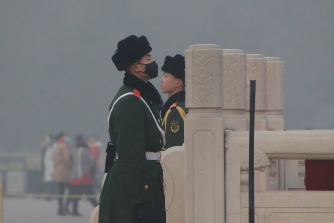 Binh sĩ Trung Quốc phải đeo khẩu trang khi đứng gác tại Bắc Kinh ngày 20-12 - Ảnh: Reuters