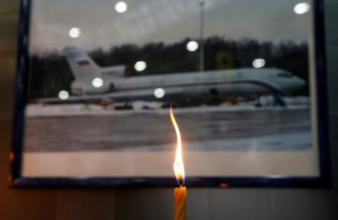 Một ngọn nến đang cháy trước bức ảnh chiếc TU-154 ở sân bay quốc tế Sochi ngày 26-12 - Ảnh: Reuters