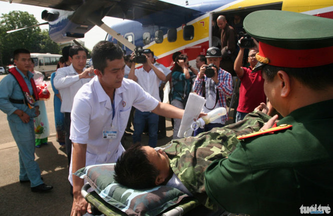 Các bác sĩ bệnh viện quân y 175 đón thiếu tá Nguyễn Văn Lâm tại cầu thang máy bay để đưa vào bệnh viện cấp cứu - Ảnh: VIỄN SỰ