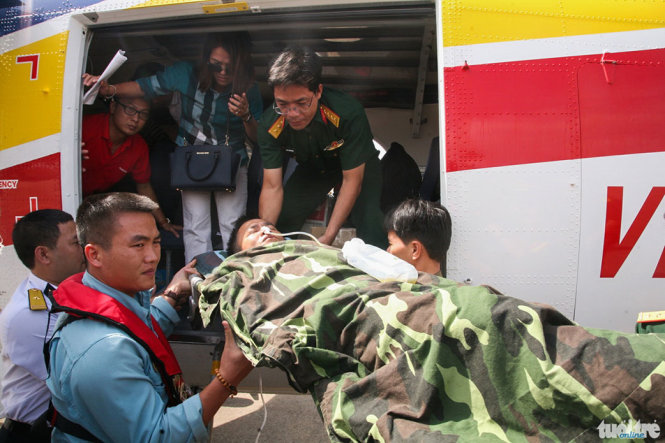 Các bác sĩ bệnh viện quân y 175 đón thiếu tá Nguyễn Văn Lâm tại cầu thang máy bay để đưa vào bệnh viện cấp cứu - Ảnh: VIỄN SỰ