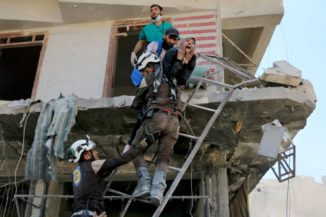 Người dân được sơ tán khỏi một tòa nhà sau khi các đợt bom không kích đánh vào khu vực do lực lượng nổi dậy kiểm soát ở Aleppo, Syria ngày 23-4-2016. Một thỏa thuận ngừng bắn tại Syria đã sụp đổ vào cuối tháng tư năm nay - Ảnh: AFP
