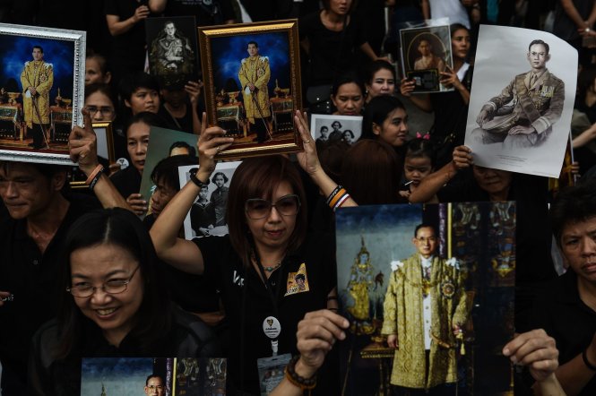 Người dân Thái cầm ảnh Thái tử Vajiralongkorn và Vua Bhumibol phía trước Cung điện Hoàng gia ở Bangkok tháng 12-2016 - Ảnh: AFP