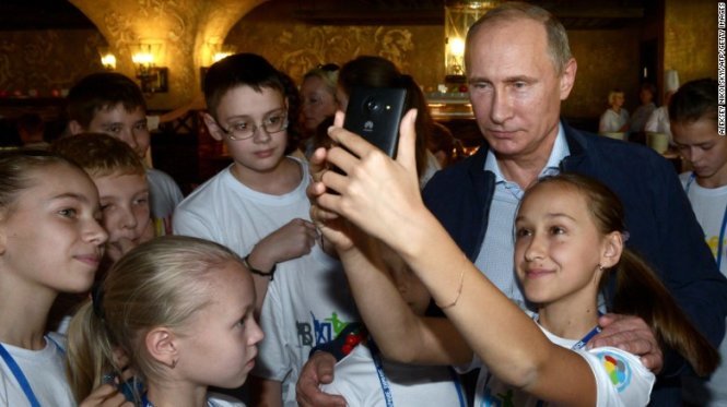 Tổng thống Nga Vladimir Putin chụp ảnh cùng các em nhỏ khi ông đến thăm Trung tâm Thể thao và Sức Khỏe Trẻ em Quốc gia tại Sochi - Ảnh: AFP