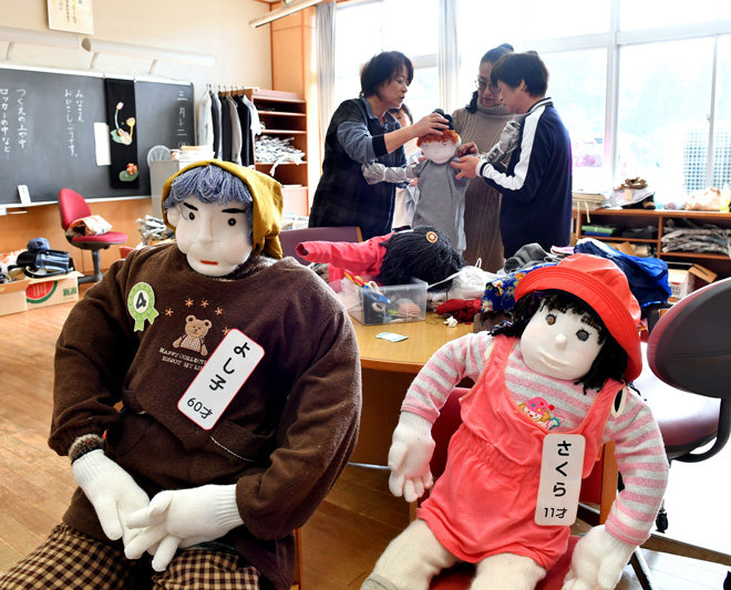 Người dân chuẩn bị những con búp bê để đem đặt ở thị trấn - Ảnh: Takuya Isayama