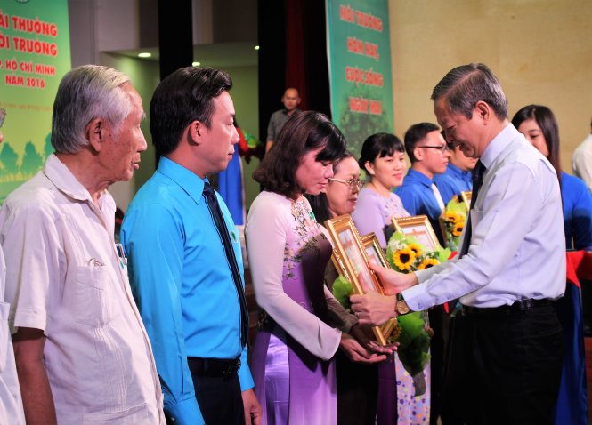 Ông Lê Văn Khoa, phó chủ tịch UBND TP.HCM, trao bằng khen và hoa cho các đơn vị, cá nhân đoạt Giải thưởng môi trường TP.HCM năm 2016 - Ảnh: Nguyễn Triều