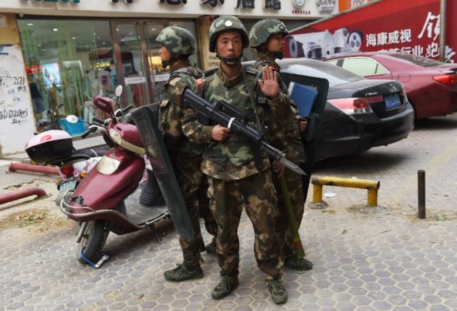 Cảnh sát bán quân sự Trung Quốc đứng gác trước một trung tâm mua sắm ở Tân Cương - Ảnh: AFP