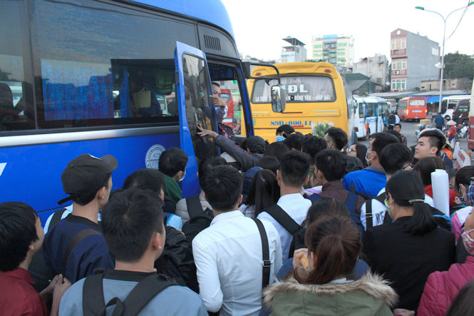 Rất đông hành khách chen chúc nhau để lên xe về quê nghỉ tết tại bến xe Giáp Bát - Ảnh: QUANG THẾ