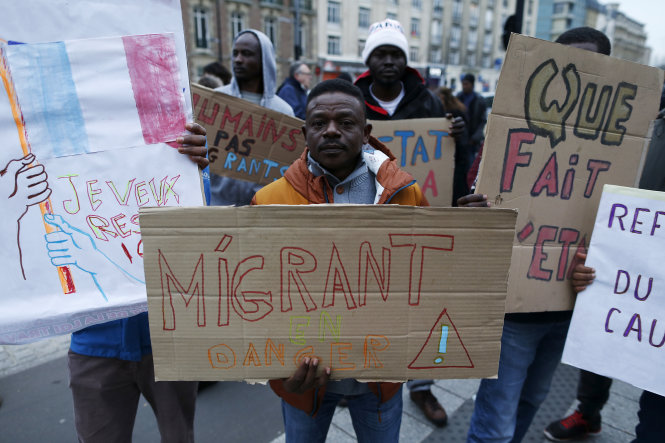 Một người nhập cư cầm tấm biển “Người nhập cư đang nguy khốn” trong một cuộc biểu tình ở Le Havre, tây bắc nước Pháp, ngày 19-12 - Ảnh: AFP