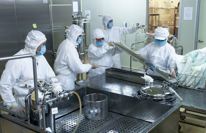 Các cán bộ kỹ thuật làm việc trong dây chuyền sản xuất vắcxin sởi - rubella - Ảnh: Cơ quan Hợp tác quốc tế Nhật Bản cung cấp