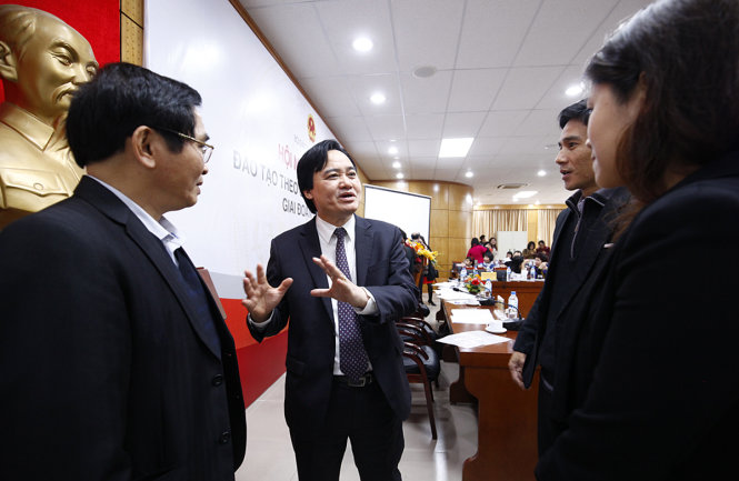 Bộ trưởng Bộ GD-ĐT Phùng Xuân Nhạ (giữa) trao đổi với các đại biểu ngoài lề tại Hội nghị  tổng kết đào tạo theo chương trình tiên tiến - Ảnh: Nam Trần