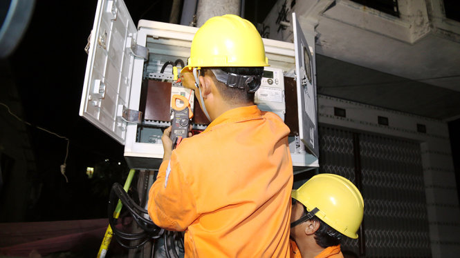 Nhân viên Công ty điện lực Kiên Giang đo điện áp sau khi đưa điện quốc gia về xã đảo Hòn Nghệ - Ảnh Đình Hoàng