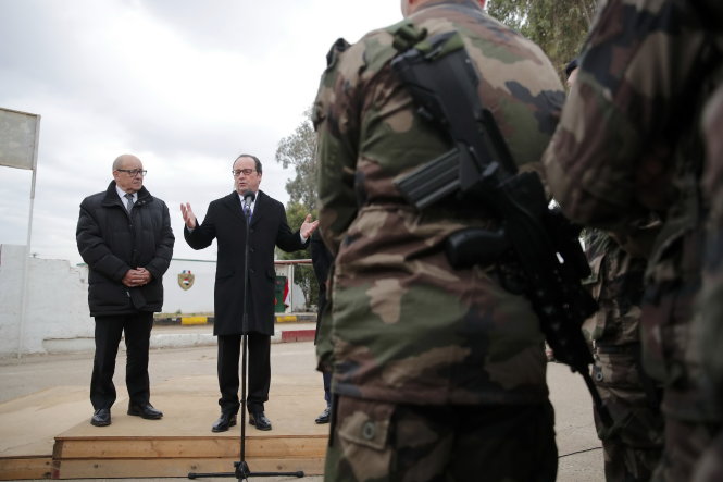 French President Francois Hollande (R) accompanied by French defense minister Jean-Yves Le Drian (L), addresses a group of French soldiers at the Iraqi Counter Terrorism Service Academy on the Baghdad Airport Complex in Baghdad