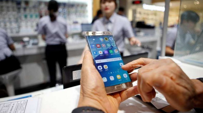 Một khách hàng mở chiếc Galaxy Note 7 khi đang chờ đổi điện thoại mới tại trụ sở chính của Samsung ở Seoul, Hàn Quốc, hôm 13-10-2016 - Ảnh: REUTERS