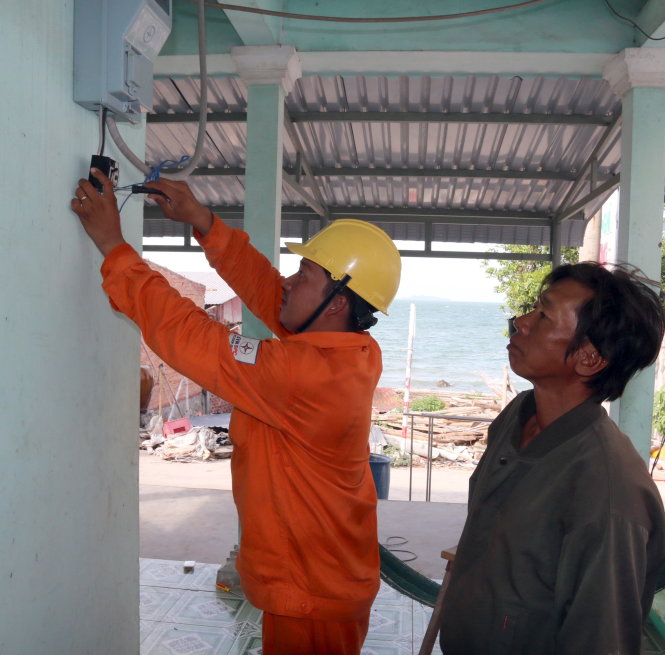 Đấu nối điện lưới quốc gia vào từng hộ dân trên đảo Hòn Nghệ - Ảnh: ĐÌNH HOÀNG