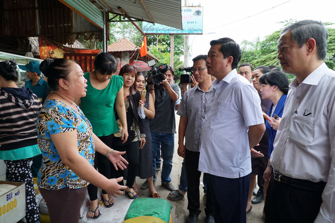 Ông Đinh La Thăng đang trao đổi với một người dân phường Thạnh Lộc bị thiệt hại sau sự cố cống Cán Dù - Ảnh: THUẬN THẮNG