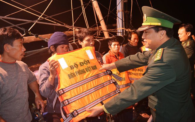 Cán bộ chiến sĩ Hải đội 2, Bộ đội biên phòng Nghệ An trao tặng áo phao cho các ngư dân gặp nạn trên tàu cá ông Thế - Ảnh: HẢI THƯỢNG