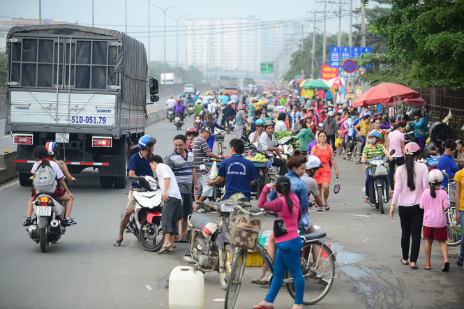Buôn bán lấn chiếm lòng đường dành cho xe máy, trong khi đó xe máy và xe đạp chạy ngược chiều trên quốc lộ 1 đoạn qua Q. Bình Tân, TP.HCM chiều 4-1 - Ảnh: Q.ĐỊNH