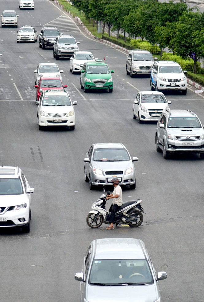 Chiếc xe máy vượt đèn đỏ chắn ngang làn ôtô đang chạy trên đường Điện Biên Phủ, Q.Bình Thạnh, TP.HCM - Ảnh: HỮU THUẬN