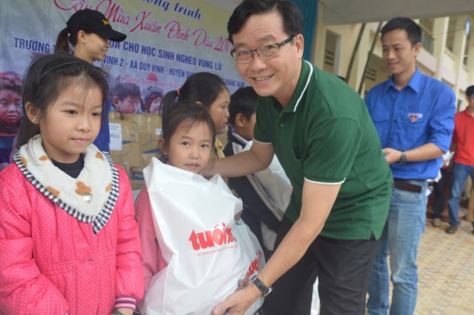 Đại diện báo Tuổi Trẻ trao tặng quần áo, tập vở và lì xì cho học sinh khó khăn - Ảnh: Thanh Ba