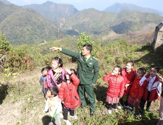 Thiếu tá Đặng Thành Long giảng giải cho học sinh về đường biên giới giữa Việt Nam và Lào trên đỉnh Mường Pồn - Ảnh: V.Hùng
