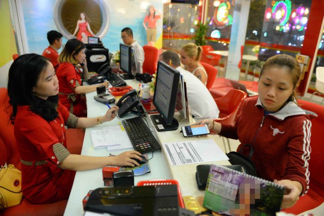 Hành khách mua vé máy bay tại một đại lý bán vé máy bay của Hãng hàng không Vietjet Air - Ảnh: Hữu Khoa
