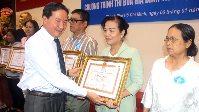 Ông Nguyễn Phương Đông, phó giám đốc Sở công thương tặng bằng khen của UBND TP cho các gia đình tiết kiệm điện năm 2016 - Ảnh: Q.Khải