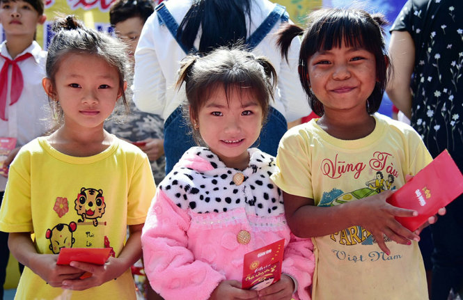 Ba bé gái người Campuchia sinh sống tại xã Bình Tân, huyện Tân Biên, Tây Ninh mừng rỡ khi nhận được quà - Ảnh: HỮU THUẬN