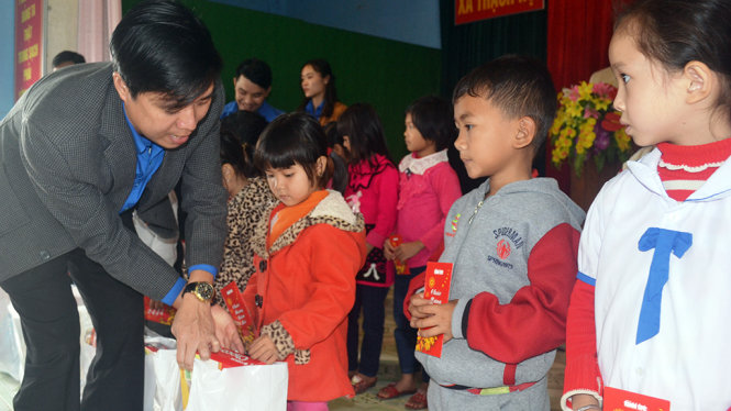 Anh Phan Kỳ - phó bí thư tỉnh Đoàn Hà Tĩnh trao quà cho các em học sinh ở xã Thạch Hội - VĂN ĐỊNH