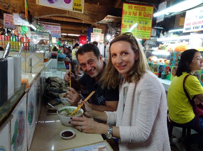 Hai vị khách nước ngoài thưởng thức bún bò Huế tại chợ Bến Thành, Q.1, TP.HCM (ảnh chụp chiều 6-1) - Ảnh: DUYÊN PHAN
