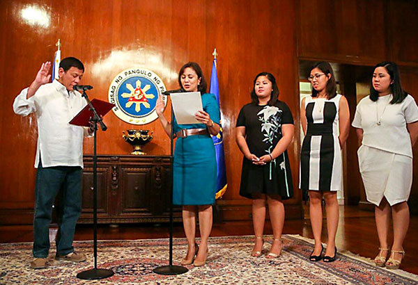Phó tổng thống Leni Robredo trong lễ tuyên thệ nhậm chức Chủ tịch Hội đồng Điều phối Nhà ở và Phát triển Đô thị trước tổng thống Rodrigo Duterte ngày 12-1-2016 trước sự chứng kiến của các con gái bà là Jillian, Tricia và Aika - Ảnh: Philstar