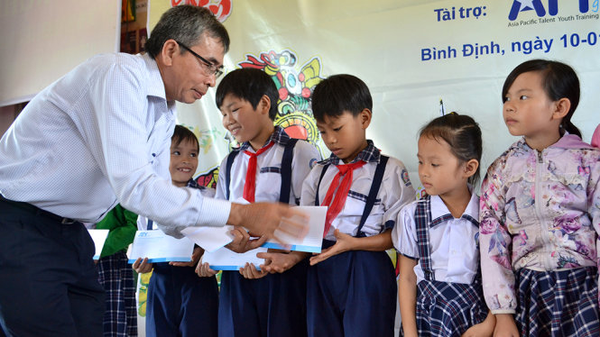 Ông Quách Hồng Dục - phó chủ tịch Hội Nông dân tỉnh Bình Định – trao quà tết của Tuổi Trẻ cho học sinh ở P.Nhơn Hòa (thị xã An Nhơn) - Ảnh: DUY THANH