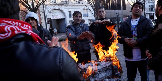 Người nhập cư sưởi ấm ở ngoại ô Paris - Ảnh: AFP