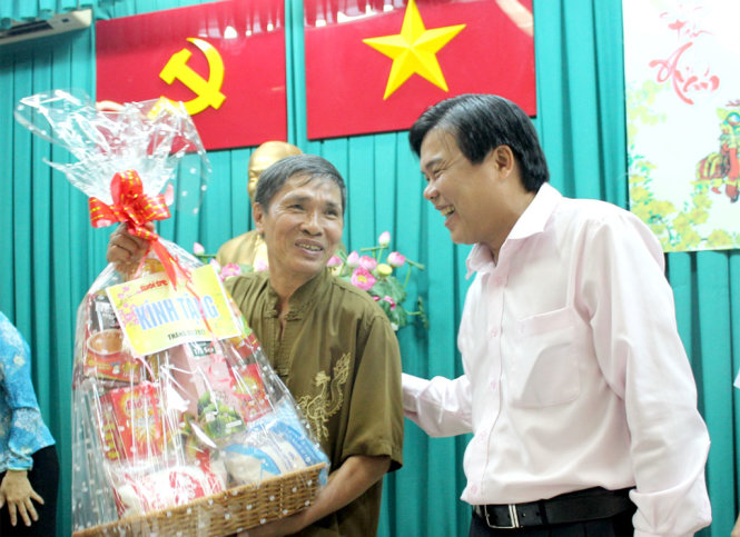 Niềm vui của người dân Q.Tân Phú (bên trái) khi nhận quà Tết - Ảnh: M.HOA