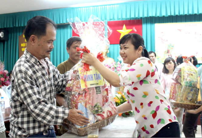Bà Nguyễn Thị Hương thay mặt báo Tuổi Trẻ tặng quà Tết cho các hộ dân - Ảnh: M.HOA