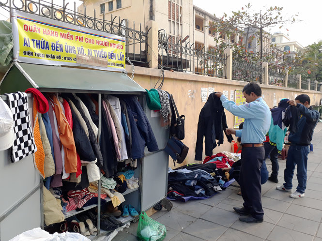 Người lao động nghèo chọn đồ tại tủ quần áo nghĩa tình trên phố Nguyễn Chí Thanh - Ảnh: QUANG THẾ