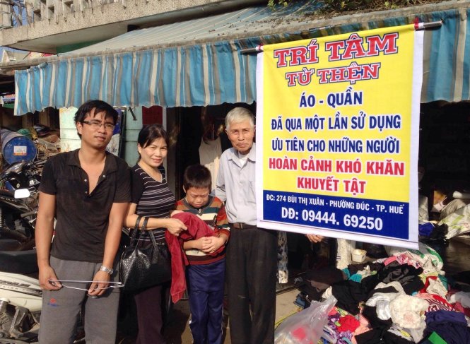 Anh Nguyễn Phan Tiến Dũng (bìa trái) cùng quầy áo quần miễn phí của mình - Ảnh: B.THANH