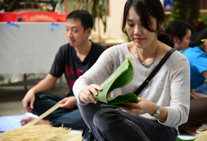 Cô bạn Ai Kawakami, luật sư người Nhật, tham gia gói bánh chưng, trải nghiệm không khí tết cổ truyền tại VN - Ảnh: HỮU THUẬN
