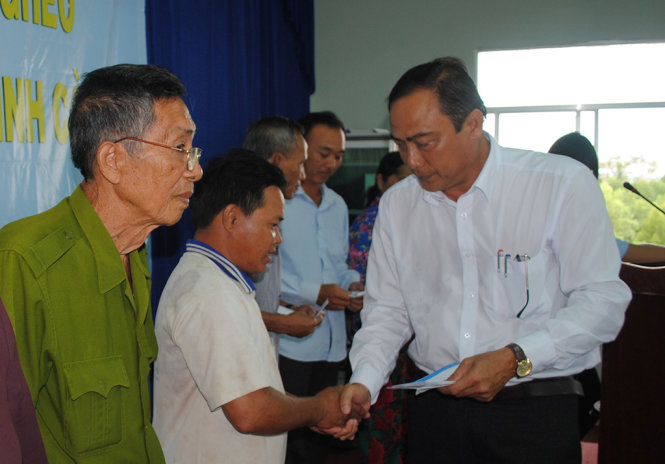 Ông Trần Hoàng Lạc (phó chủ tịch UBND huyện Ngọc Hiển) trao quà xuân cho người nghèo