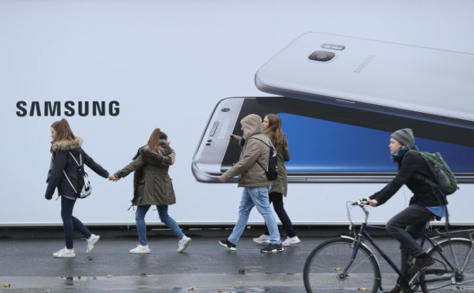 Người dân đi qua một tấm pano quảng cáo điện thoại Galaxy S7 Edge của Samsung ở Berlin, Đức - Ảnh: Sean Gallup/Getty Images