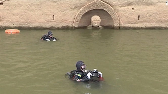 Các chuyên gia khảo cổ học của Trung Quốc mặt đồ thợ lặn nghiên cứu bức tượng - Ảnh: CCTV