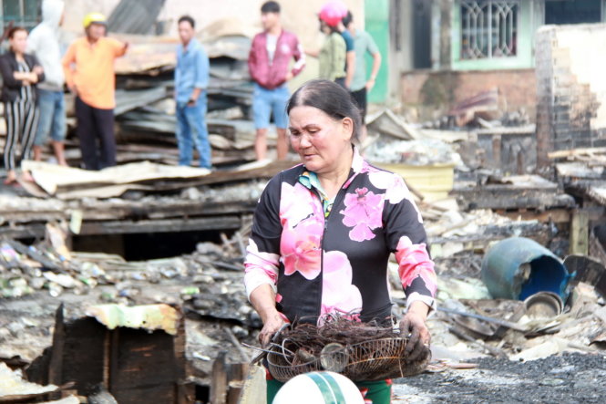 Người dân nhặt nhạnh tài sản sau vụ cháy - Ảnh: Trung Tân