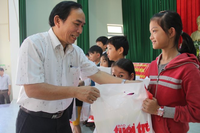 Ông Thời, phó chủ tịch UBND huyện Nghĩa Hành trao quà tết và động viên học trò đến lớp - Ảnh: Trần Mai
