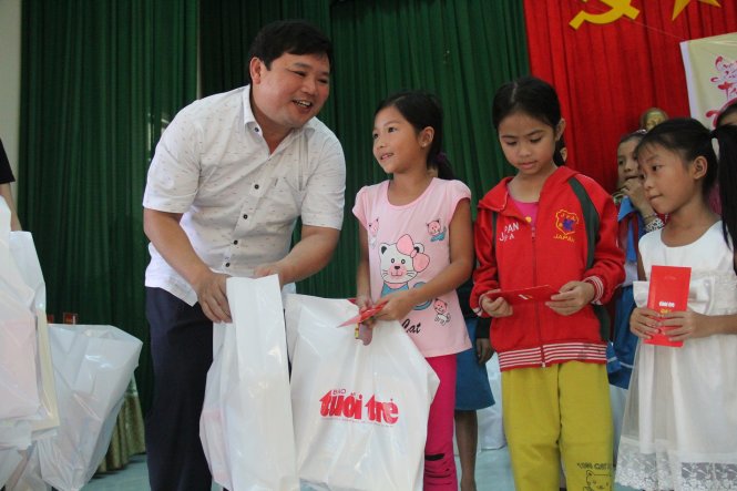 Ông Thảo, giám đốc Qũy Bảo trợ trẻ em tỉnh Quảng Ngãi trao quà cho trẻ em vùng rốn lũ Nghĩa Hành - Ảnh: Trần Mai