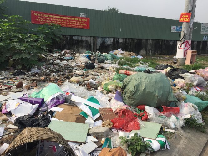 Bãi rác lộ thiên ngay dưới biển cấm đổ rác trên đường Bờ Bao Tân Thắng, P.Sơn Kỳ, Q.Tân Phú - Ảnh: N.TRIỀU