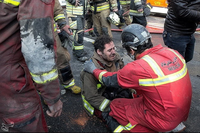 Lính cứu hỏa bị thương sau vụ sụp tòa nhà - Ảnh: Reuters