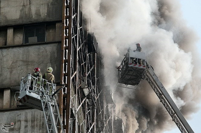 Lực lượng cứu hỏa tiếp cận tòa nhà khi nó đang cháy - Ảnh: Reuters