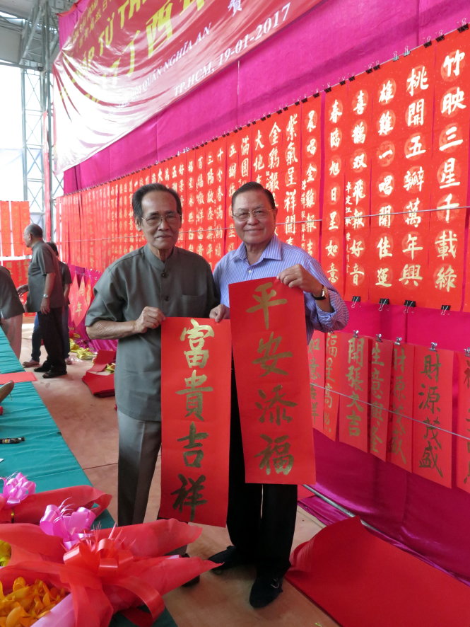 Doanh nhân Lữ Vĩnh Hùng (phải) nhận câu đối từ họa sĩ Lý Tùng Niên - Ảnh: L.Điền