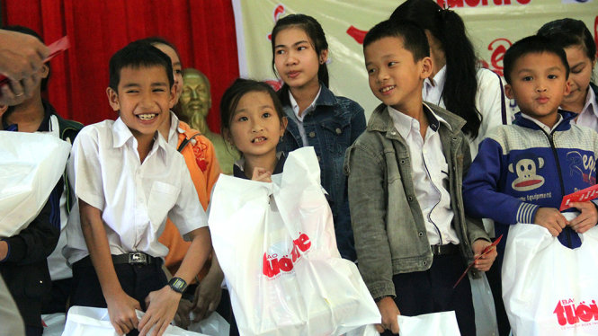 Học sinh vùng lũ xã Hoài Mỹ (Hoài Nhơn, Bình Định) với những túi quà của bạn đọc báo Tuổi Trẻ - Ảnh: D.THANH
