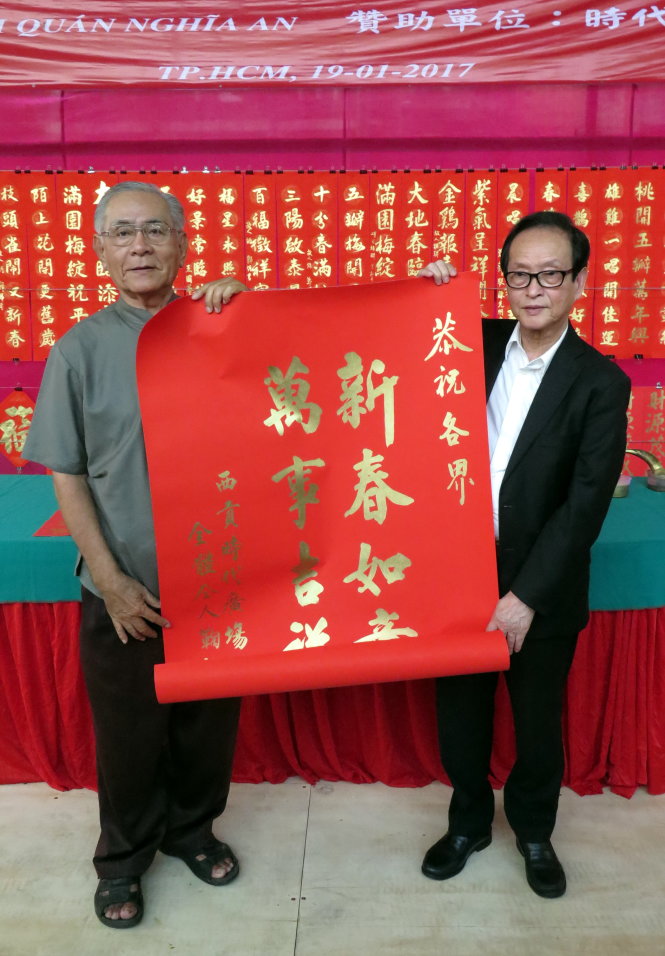 Thư pháp gia Trần Tiên Minh (bên trái – đại diện Hội thư pháp) tặng ông Trương Phong Vũ – đại diện Times Square – bức chữ “Tân xuân như ý, vạn sự cát tường” - Ảnh: L.Điền