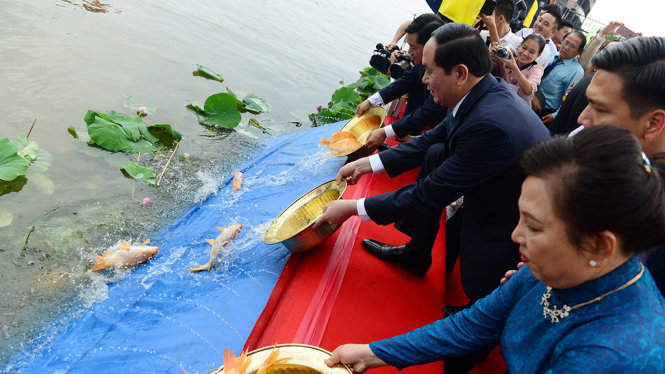 Chủ tịch nước Trần Đại Quang và Bí thư Thành ủy TP.HCM Đinh La Thăng thả cá tại Bến Nhà Rồng chiều 20-1 - Ảnh: QUANG ĐỊNH